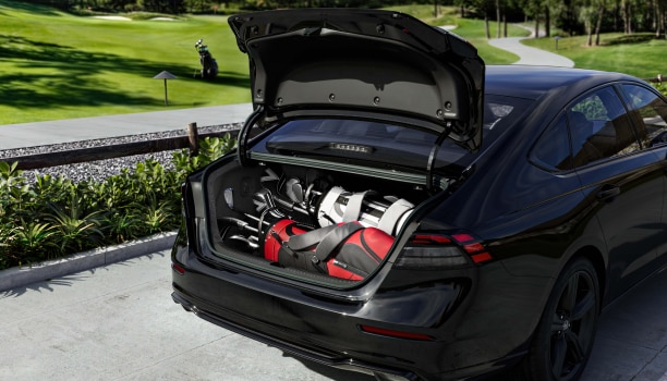 Plan large du coffre ouvert d’une Accord noire avec deux sacs de golf.