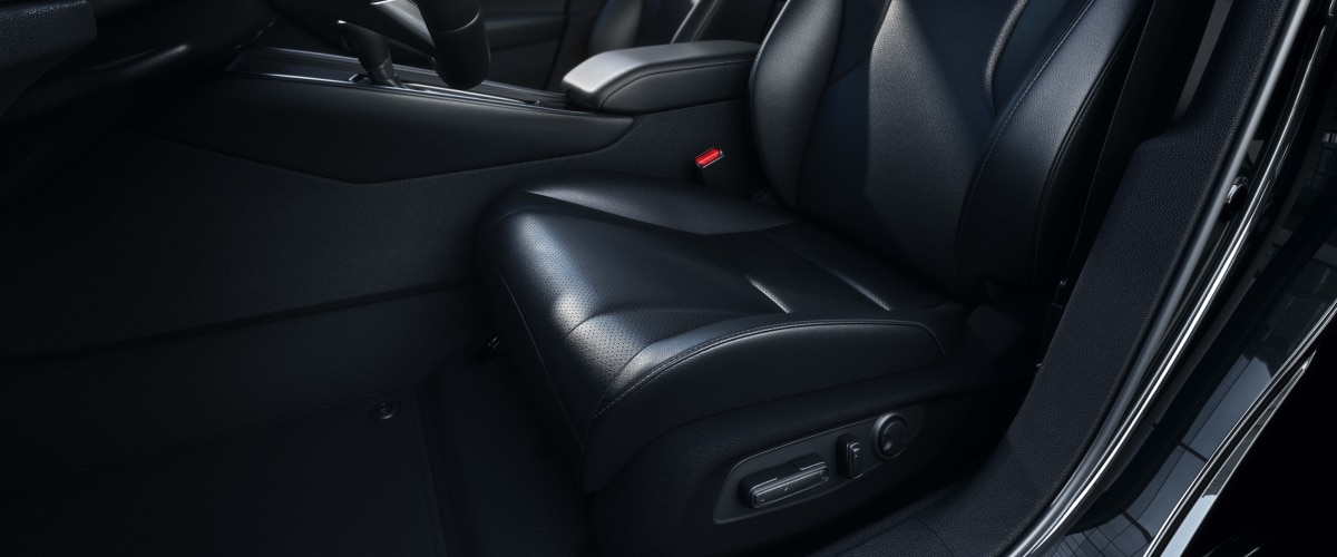 Closeup view of black leather-trimmed driver’s seat.