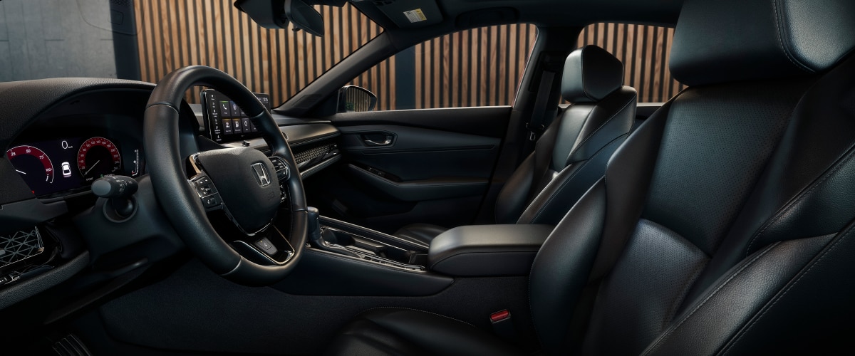 Driver’s side view of first row of seating. Trendy building with wood panelling can be seen out the window.