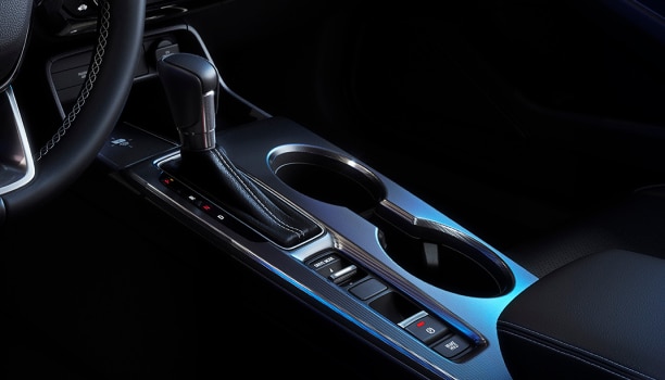Closeup of gear shifter and cupholder console.