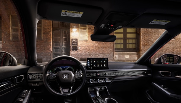 Interior panoramic view of the windshield on a Hatchback parked in front of brick wall in an old warehouse district.