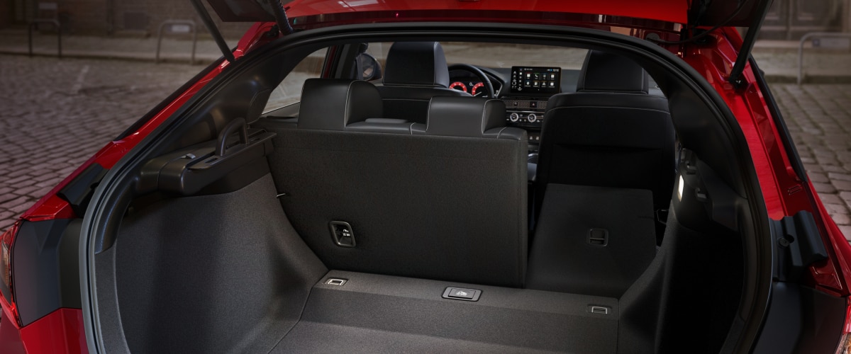 Closeup of open hatch on red hatchback displaying the cargo space.