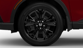  Vue latérale avant d’un CR-V rouge mettant en valeur sa roue en alliage d’aluminium noir. 