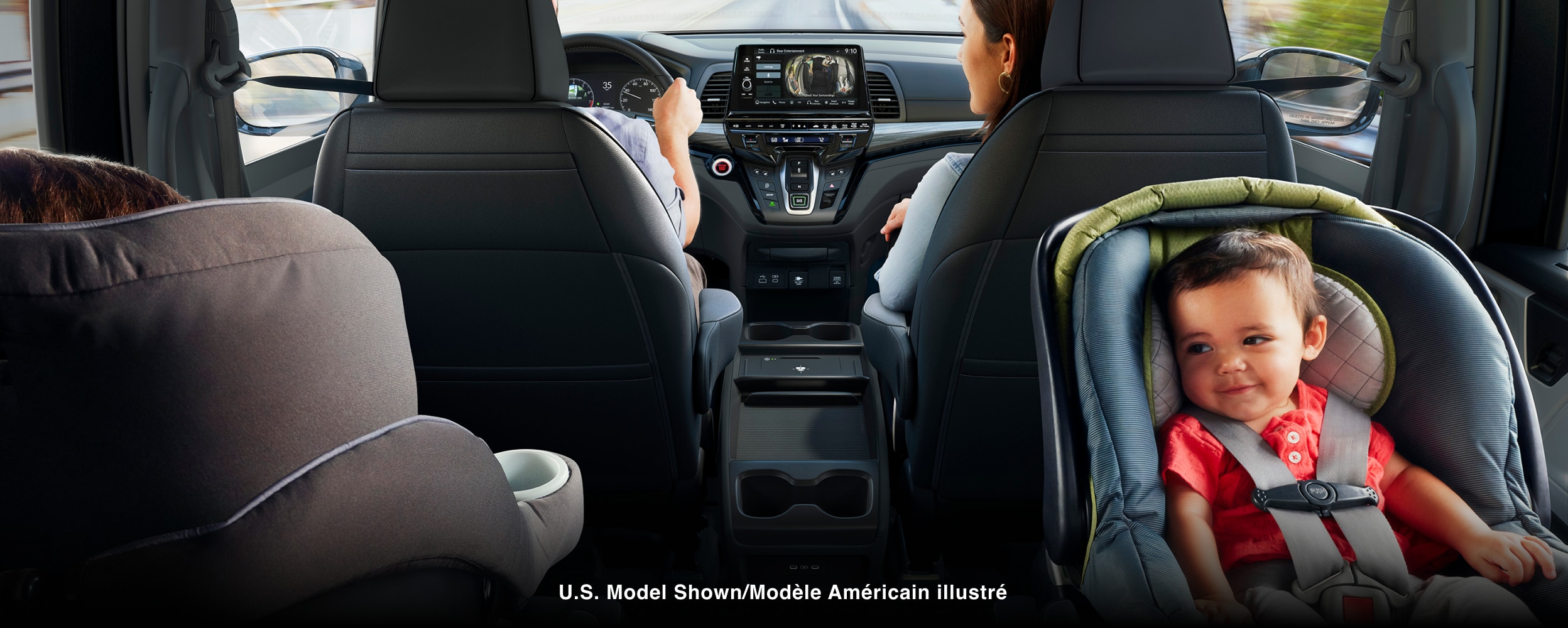 Habitacle de l’Odyssey. Père au volant; mère dans le siège passager avant; enfant dans son siège d’auto.