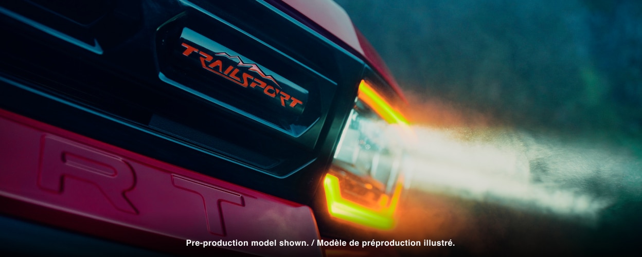 Closeup of front grill with headlights on.