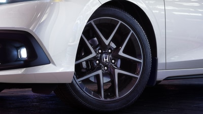Closeup of wheel on a white Hatchback. 