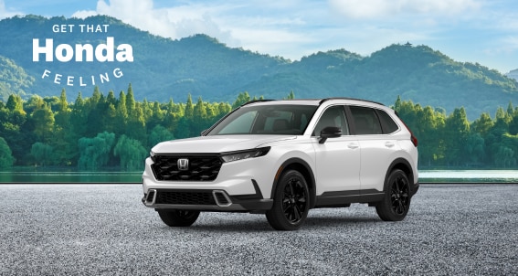 The white 2024 CR-V on the background with lake and forest in summer. Get That Honda Feeling logo on bottom right.