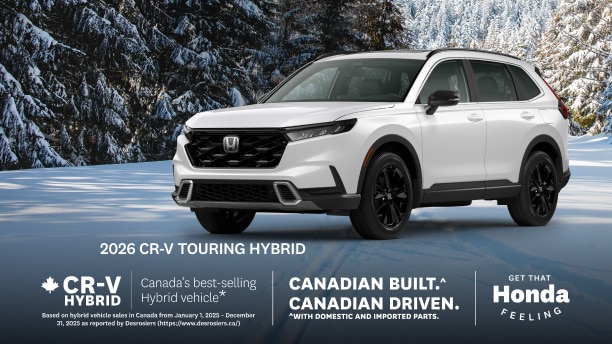 A white Honda CR-V parked on a wintery road with snow covered trees behind.