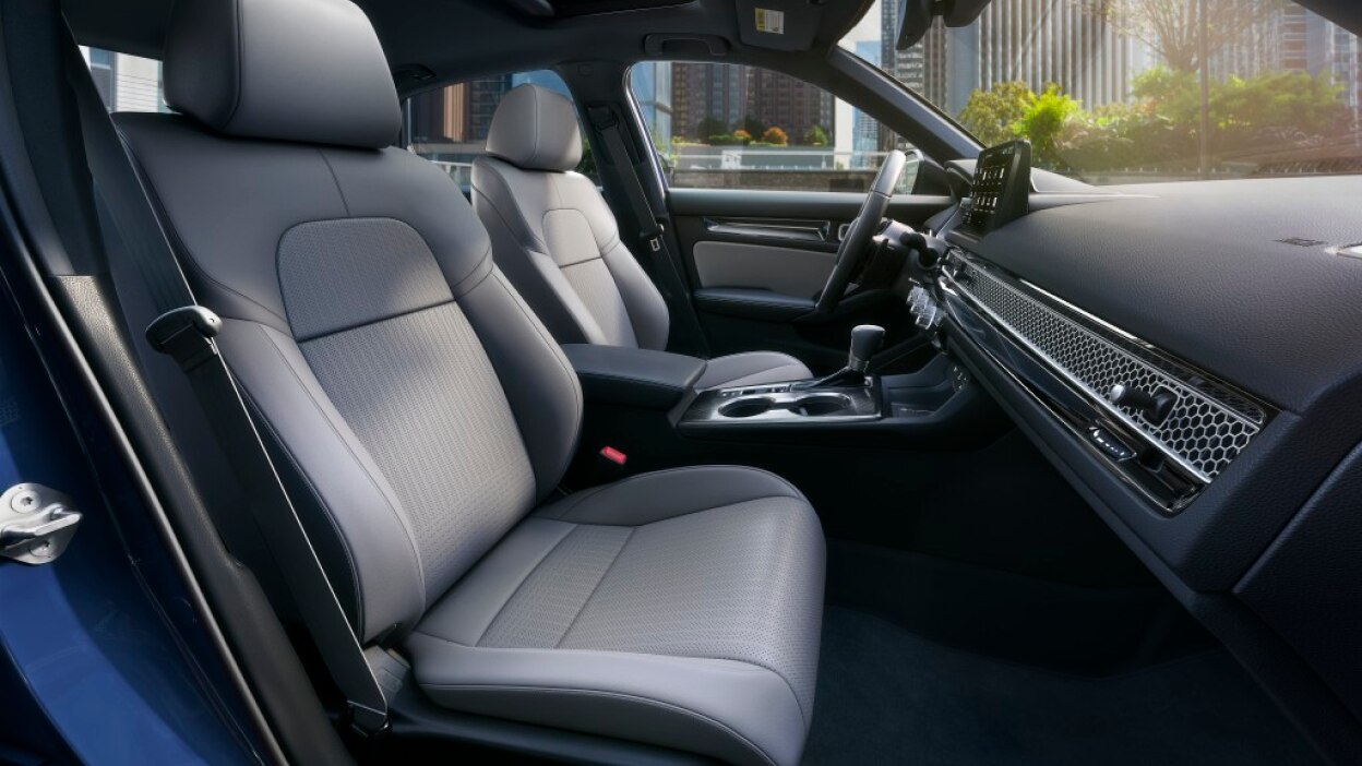 Side view of front row, passenger side, showcasing grey front seats, dashboard, centre console, and steering wheel.