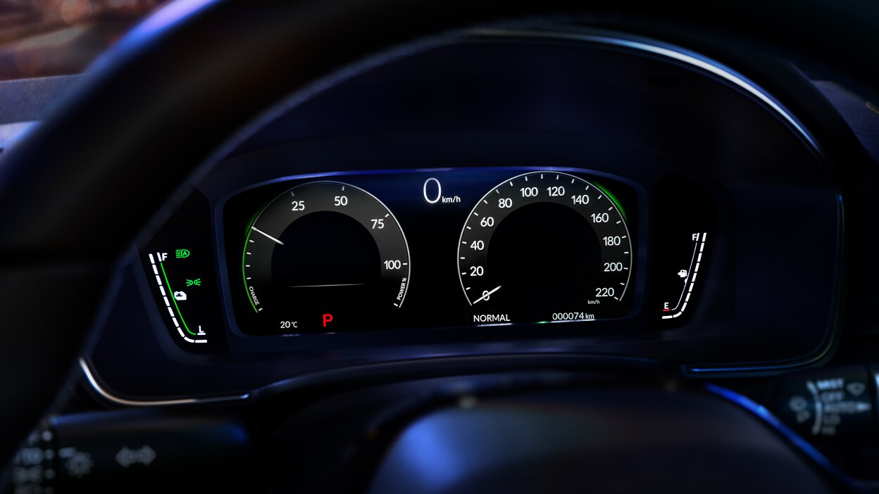 Closeup of colour TFT Centre Meter Display, seen through steering wheel, showing the speedometer, tachometer, fuel gauge, and engine temperature readout.