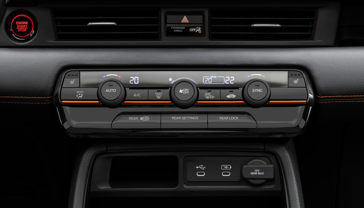 Gros plan sur le panneau de commande de la climatisation du Pilot, avec les boutons et les cadrans de réglage de la température.